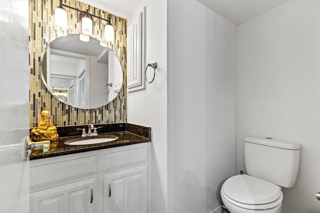 5626 Preston Oaks Road, Unit 51D Dallas, TX 75254 - Photo 5 of 19 a bathroom with a toilet a sink and mirror