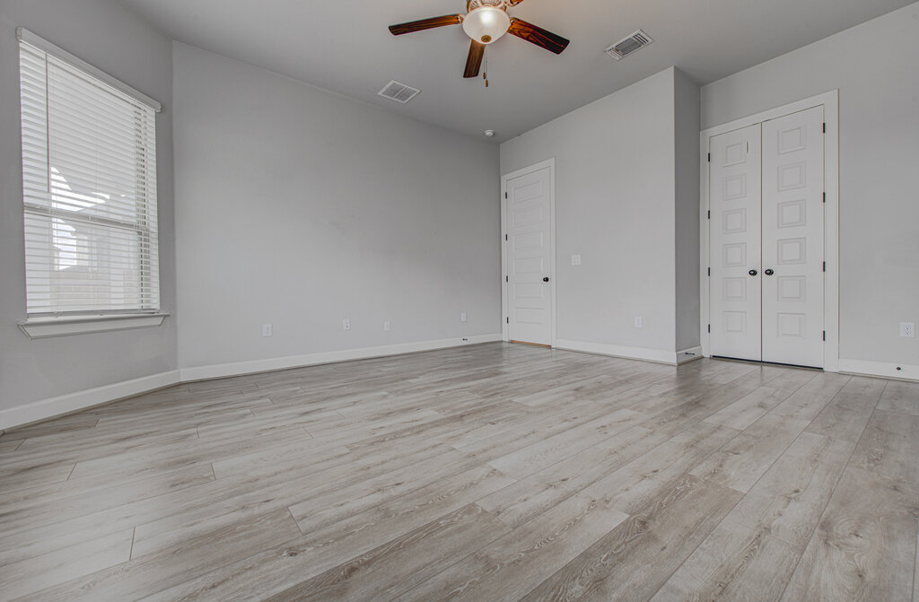 2903 Sebring Circle Austin, TX 78747 - Photo 15 of 31 an empty room with wooden floor chandelier fan and windows