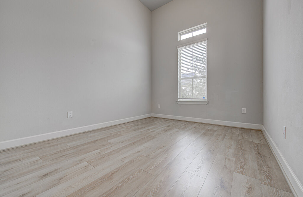 2903 Sebring Circle Austin, TX 78747 - Photo 4 of 31 an empty room with wooden floor and windows