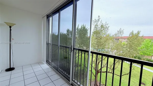 a view of a big room with wooden floor and windows