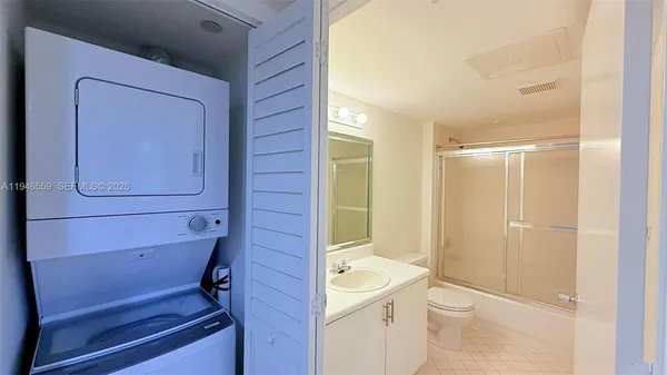 a bathroom with a granite countertop toilet a sink and shower