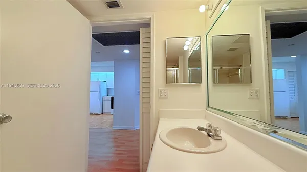a kitchen with a sink dishwasher stove and white cabinets