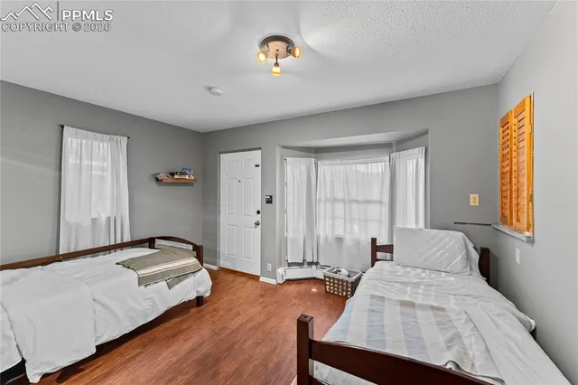 a spacious bedroom with a bed and wooden floor