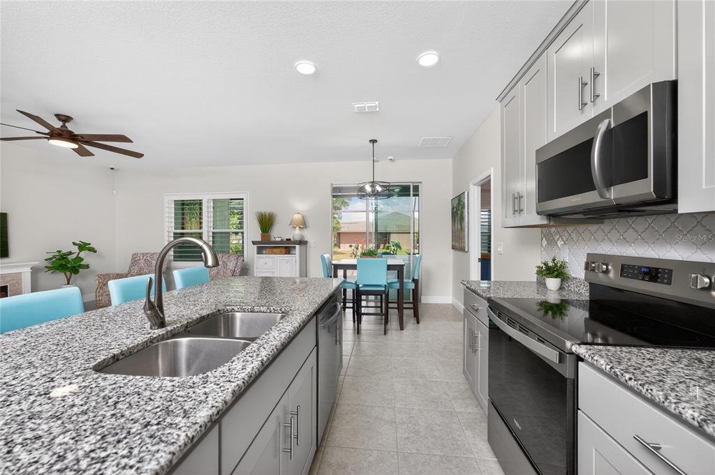27366 Deep Creek Boulevard Punta Gorda, FL 33983 - Photo 11 of 63 a kitchen with stainless steel appliances granite countertop a sink a stove top oven a counter space and cabinets