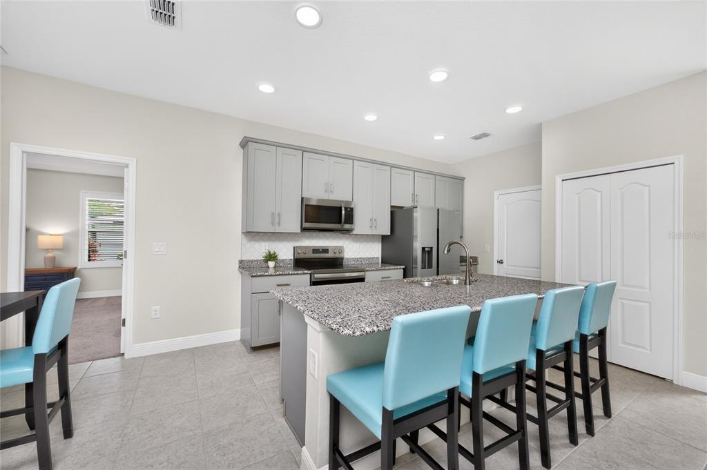 27366 Deep Creek Boulevard Punta Gorda, FL 33983 - Photo 12 of 63 a kitchen with kitchen island granite countertop a dining table chairs stainless steel appliances and cabinets