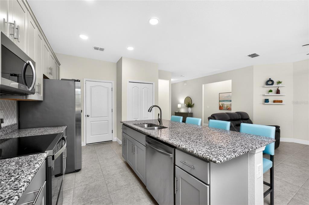 27366 Deep Creek Boulevard Punta Gorda, FL 33983 - Photo 14 of 63 a kitchen with granite countertop kitchen island stainless steel appliances a sink stove and refrigerator
