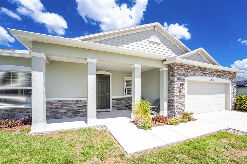 27366 Deep Creek Boulevard Punta Gorda, FL 33983 - Photo 59 of 63 a front view of a house with a yard outdoor seating and garage