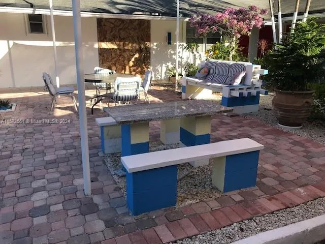 a view of a patio with table and chairs potted plants