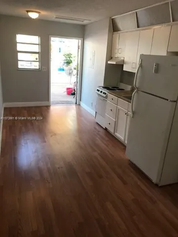 a kitchen with granite countertop a stove and a wooden floor