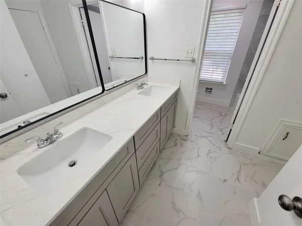 a bathroom with a double vanity sink and mirror