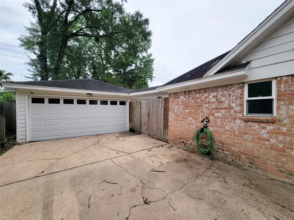 a backyard of a house with potted plants and large tree