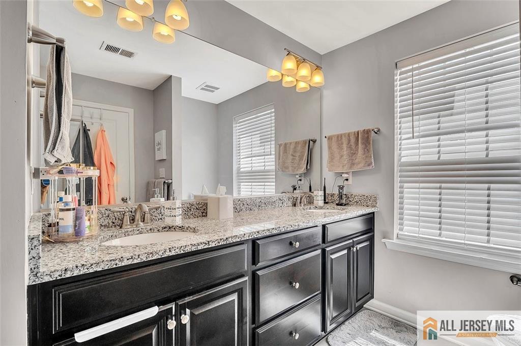 1501 Hights Farm Road South, Unit 1501 Monroe Township, NJ 08831 - Photo 24 of 30 a bathroom with a granite countertop sink and a mirror