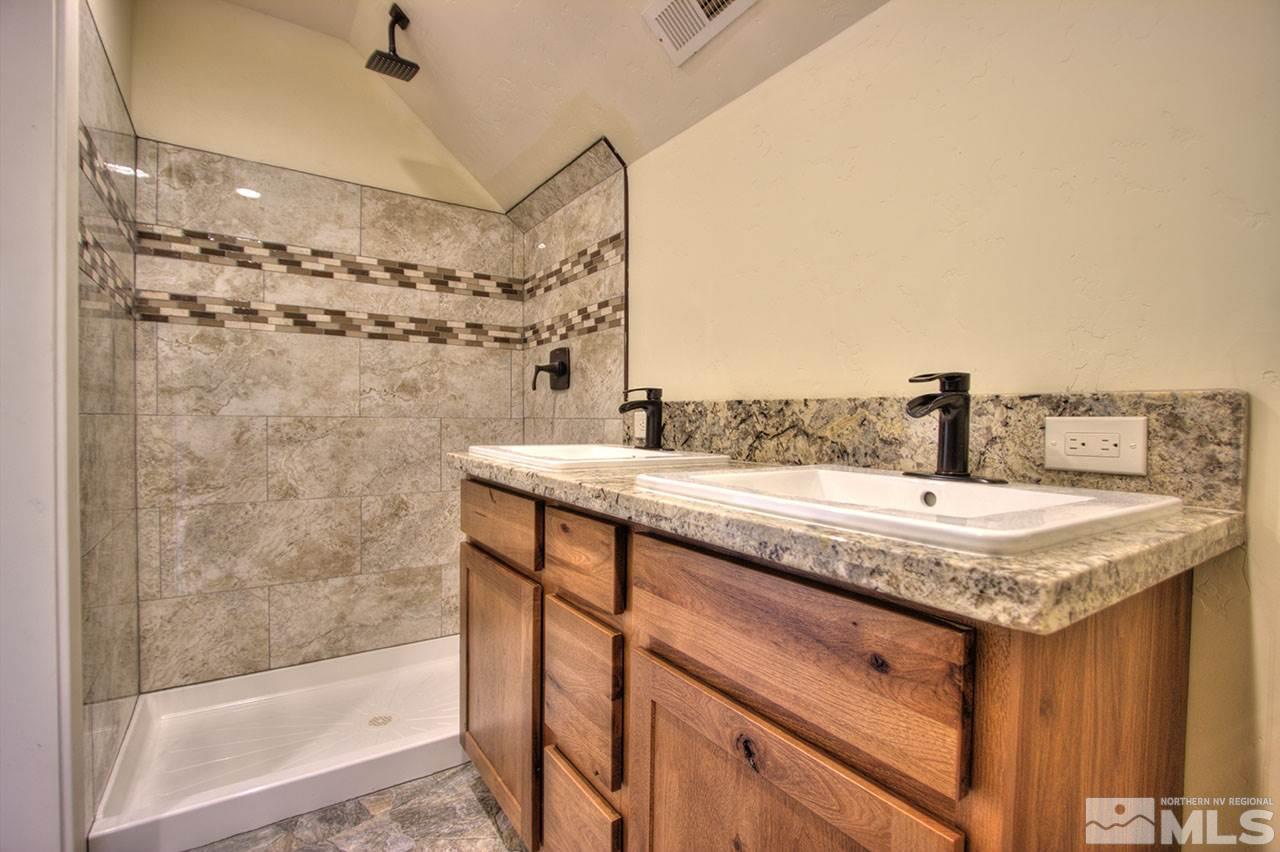 2240 Lousetown Road Reno, NV 89521 - Photo 21 of 25 a bathroom with a granite countertop sink a mirror and shower