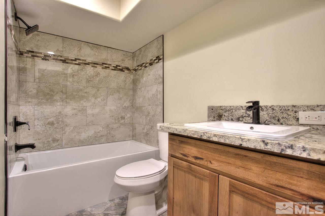 2240 Lousetown Road Reno, NV 89521 - Photo 6 of 25 a bathroom with a granite countertop sink a toilet and bathtub