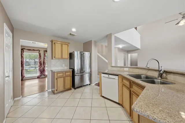 a kitchen with stainless steel appliances granite countertop a sink and a refrigerator