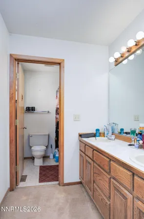 a spacious bathroom with a toilet a sink and a mirror
