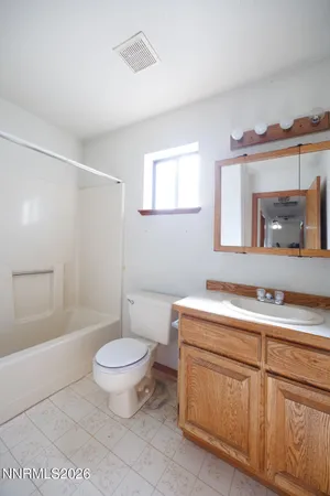 a bathroom with a granite countertop sink mirror vanity and toilet