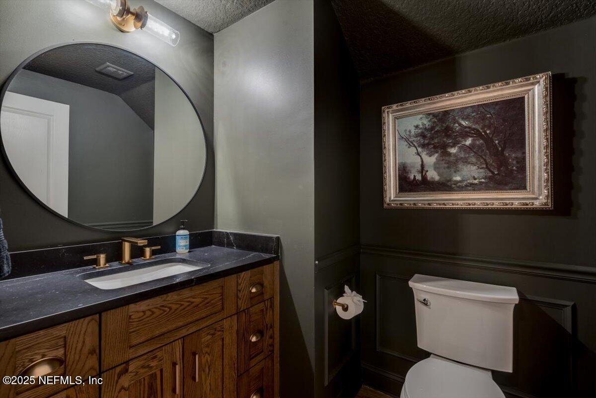 1047 Eagle Point Drive St. Augustine, FL 32092 - Photo 26 of 85 a bathroom with a toilet sink vanity and mirror