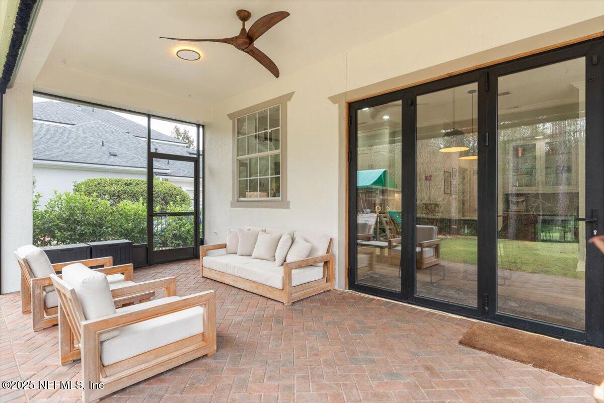 1047 Eagle Point Drive St. Augustine, FL 32092 - Photo 51 of 85 a living room with furniture and a floor to ceiling window