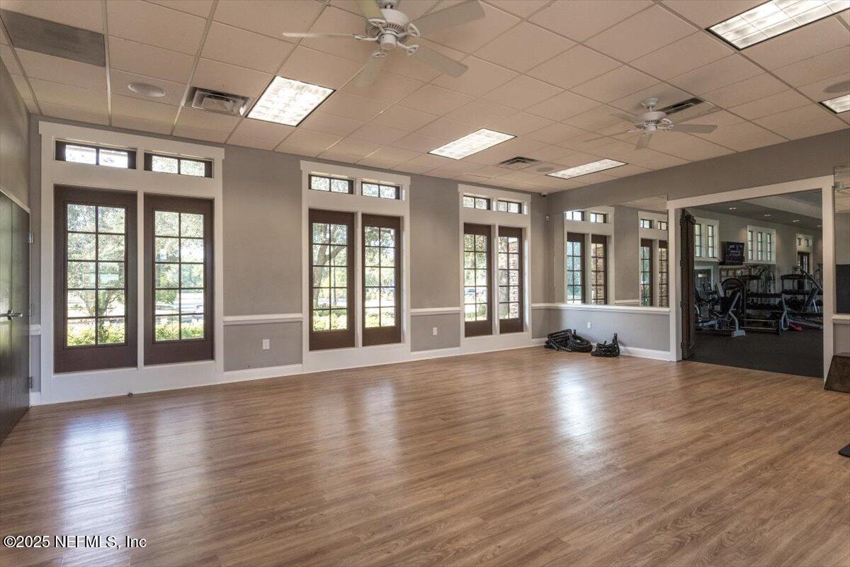 1047 Eagle Point Drive St. Augustine, FL 32092 - Photo 82 of 85 an empty room with wooden floor and large windows