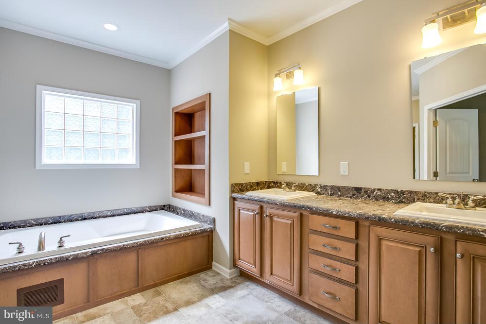 10421 Edenton Road Partlow, VA 22534 - Photo 14 of 18 a spacious bathroom with a granite countertop tub sink and mirror