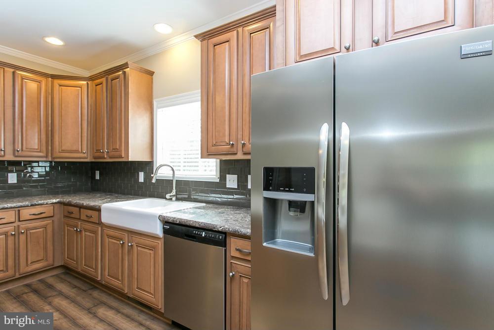 10421 Edenton Road Partlow, VA 22534 - Photo 8 of 18 a kitchen with stainless steel appliances granite countertop a refrigerator a sink and white cabinets with wooden floor