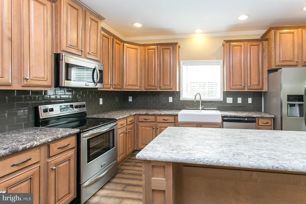 10421 Edenton Road Partlow, VA 22534 - Photo 9 of 18 a kitchen with stainless steel appliances granite countertop a stove a sink and a microwave
