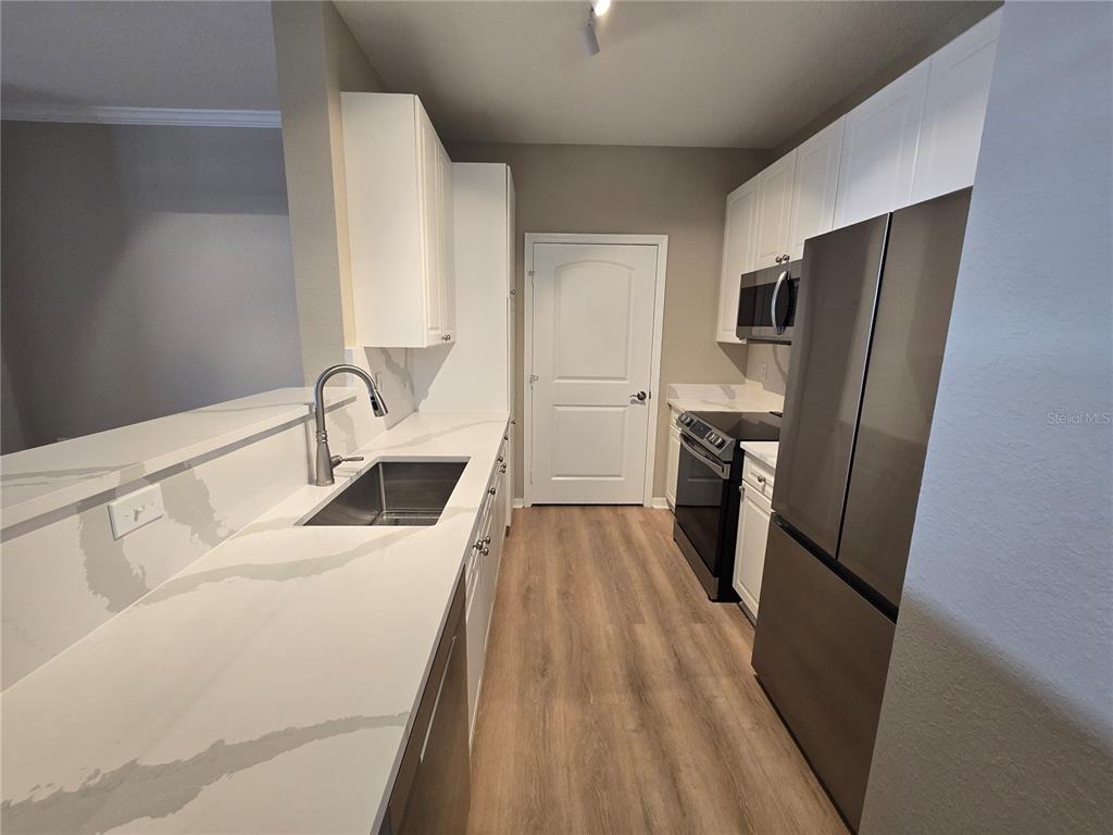 4221 West Spruce Street, Unit 2420 Tampa, FL 33607 - Photo 12 of 33 a kitchen with a sink a refrigerator freezer a stove top oven a refrigerator and cabinets