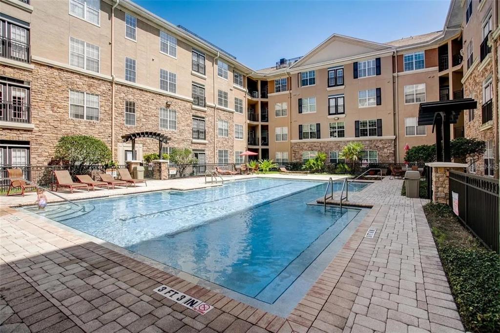 4221 West Spruce Street, Unit 2420 Tampa, FL 33607 - Photo 2 of 33 a swimming pool with outdoor seating and yard