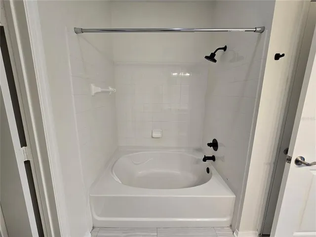 a white bath tub and shower in a bathroom