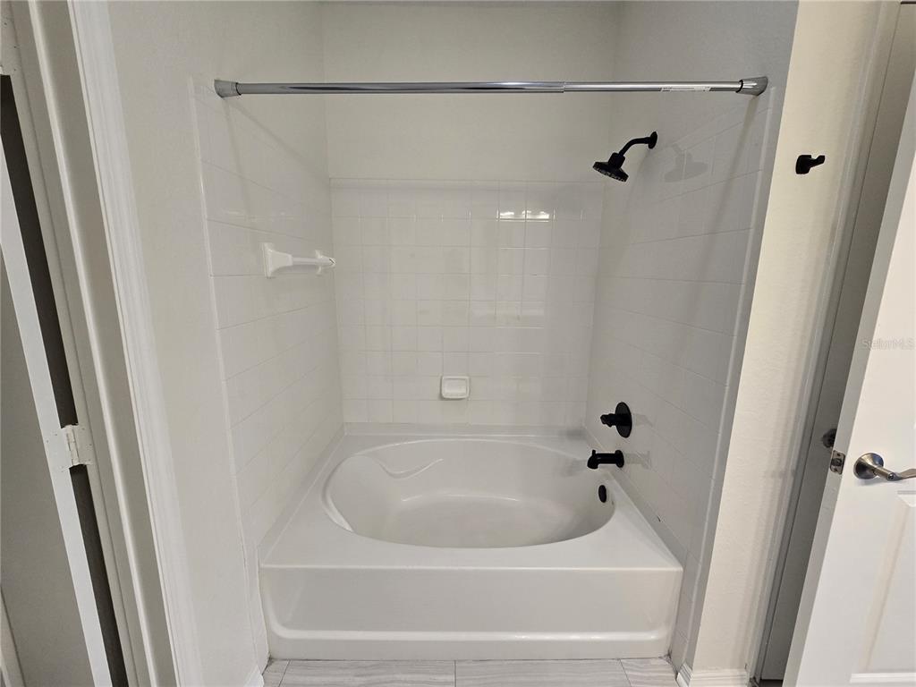 4221 West Spruce Street, Unit 2420 Tampa, FL 33607 - Photo 25 of 33 a white bath tub and shower in a bathroom