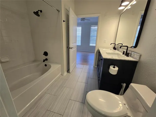a bathroom with a sink a toilet a mirror and bathtub