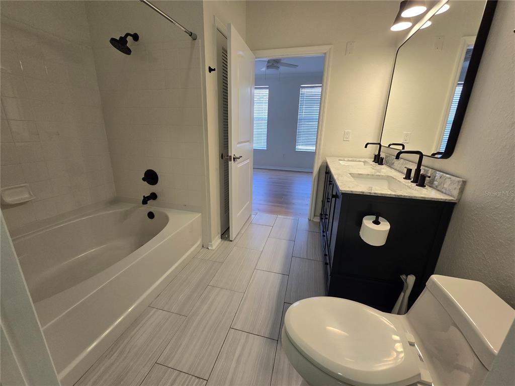 4221 West Spruce Street, Unit 2420 Tampa, FL 33607 - Photo 27 of 33 a bathroom with a sink a toilet a mirror and bathtub