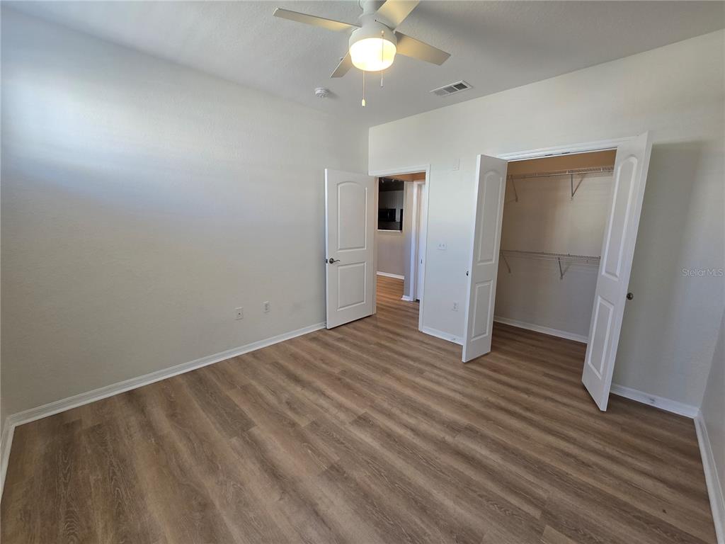 4221 West Spruce Street, Unit 2420 Tampa, FL 33607 - Photo 31 of 33 an empty room with wooden floor and a ceiling fan