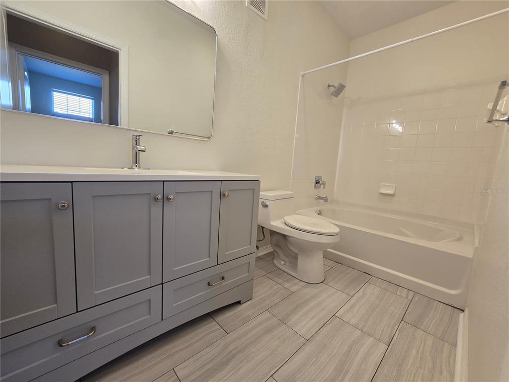 4221 West Spruce Street, Unit 2420 Tampa, FL 33607 - Photo 32 of 33 a bathroom with a sink a toilet and shower