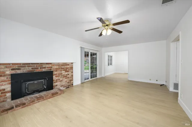 a view of empty room with fireplace and windows