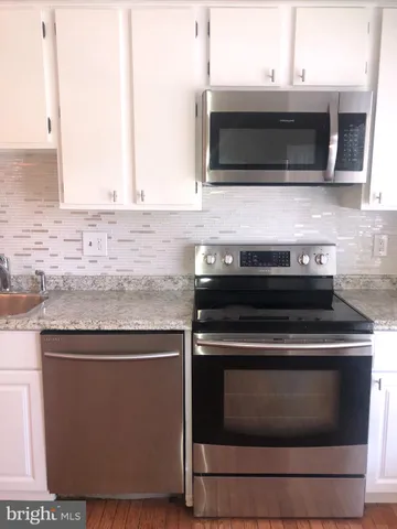 a kitchen with granite countertop a stove and a microwave