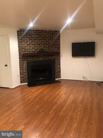 a view of empty room with wooden floor and fireplace