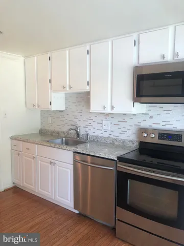 a kitchen with granite countertop white cabinets and appliances