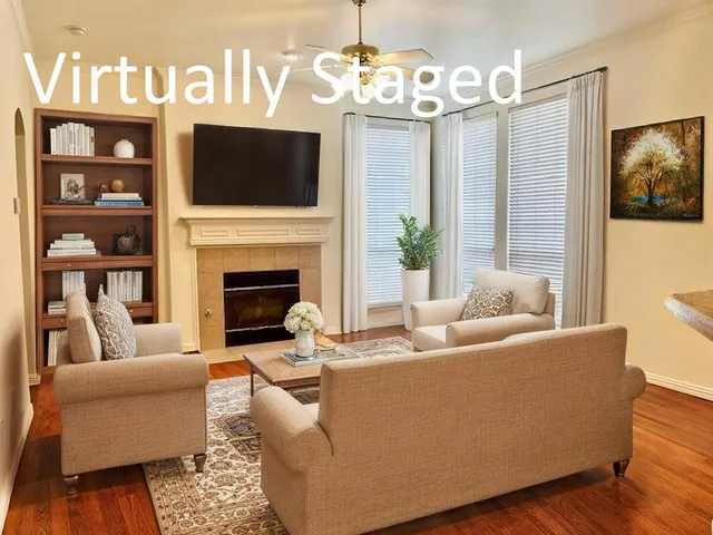 a living room with furniture a flat screen tv and a fireplace