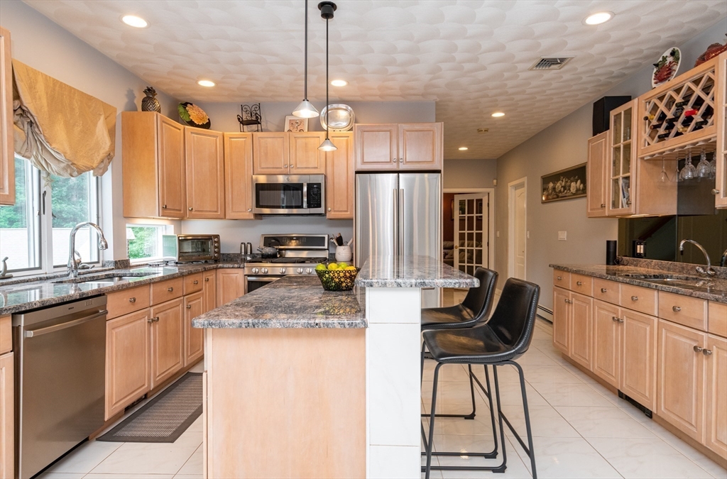 11 Hood Farm Road Ipswich, MA 01938 - Photo 17 of 42 a kitchen with stainless steel appliances kitchen island granite countertop a sink a stove a refrigerator and cabinets