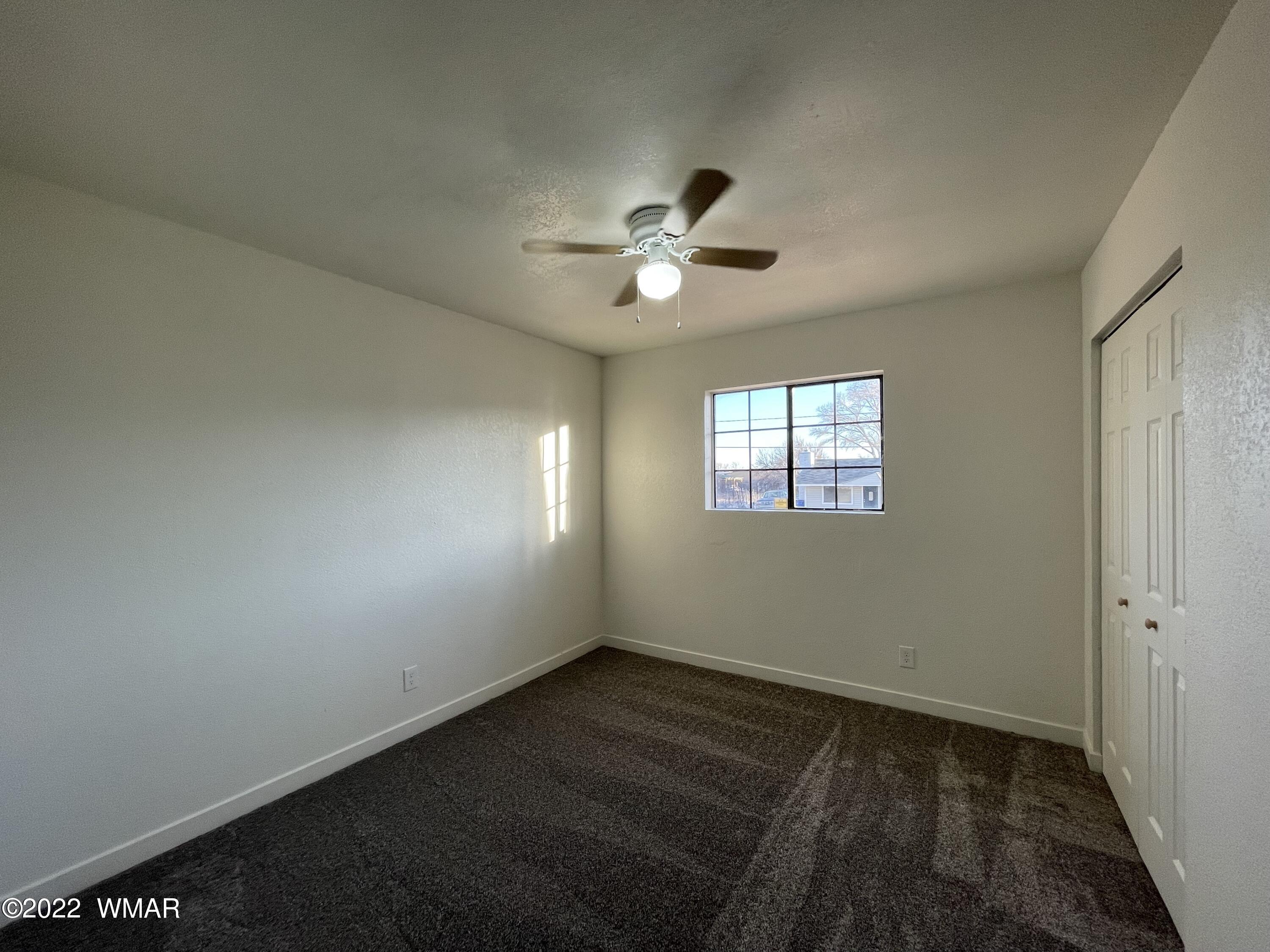 118 East 9th S Street Snowflake, AZ 85937 - Photo 11 of 19 an empty room with a window and a ceiling fan