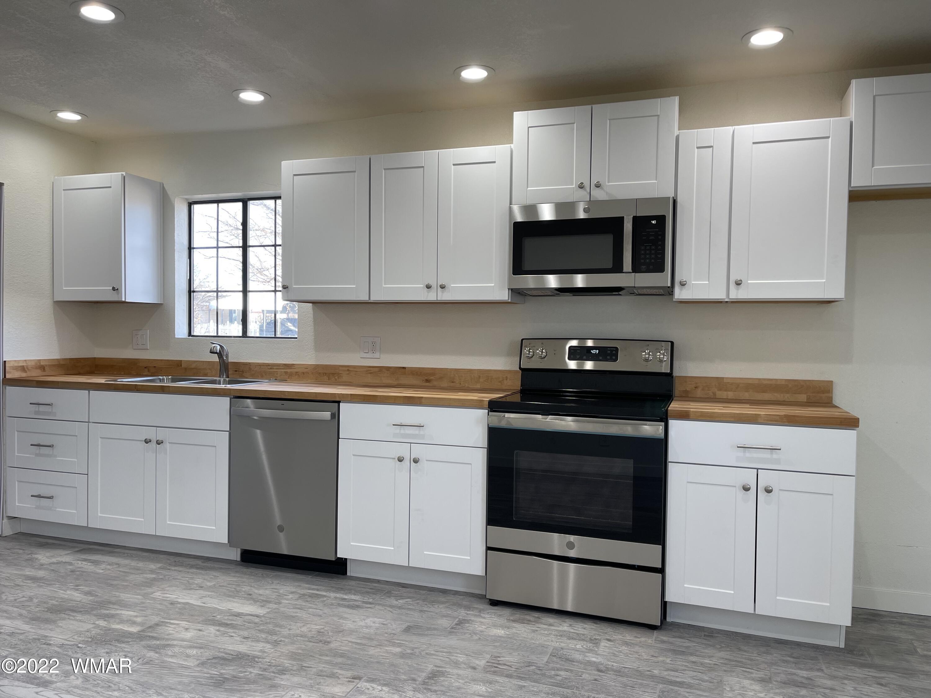 118 East 9th S Street Snowflake, AZ 85937 - Photo 5 of 19 a kitchen with granite countertop white cabinets and stainless steel appliances