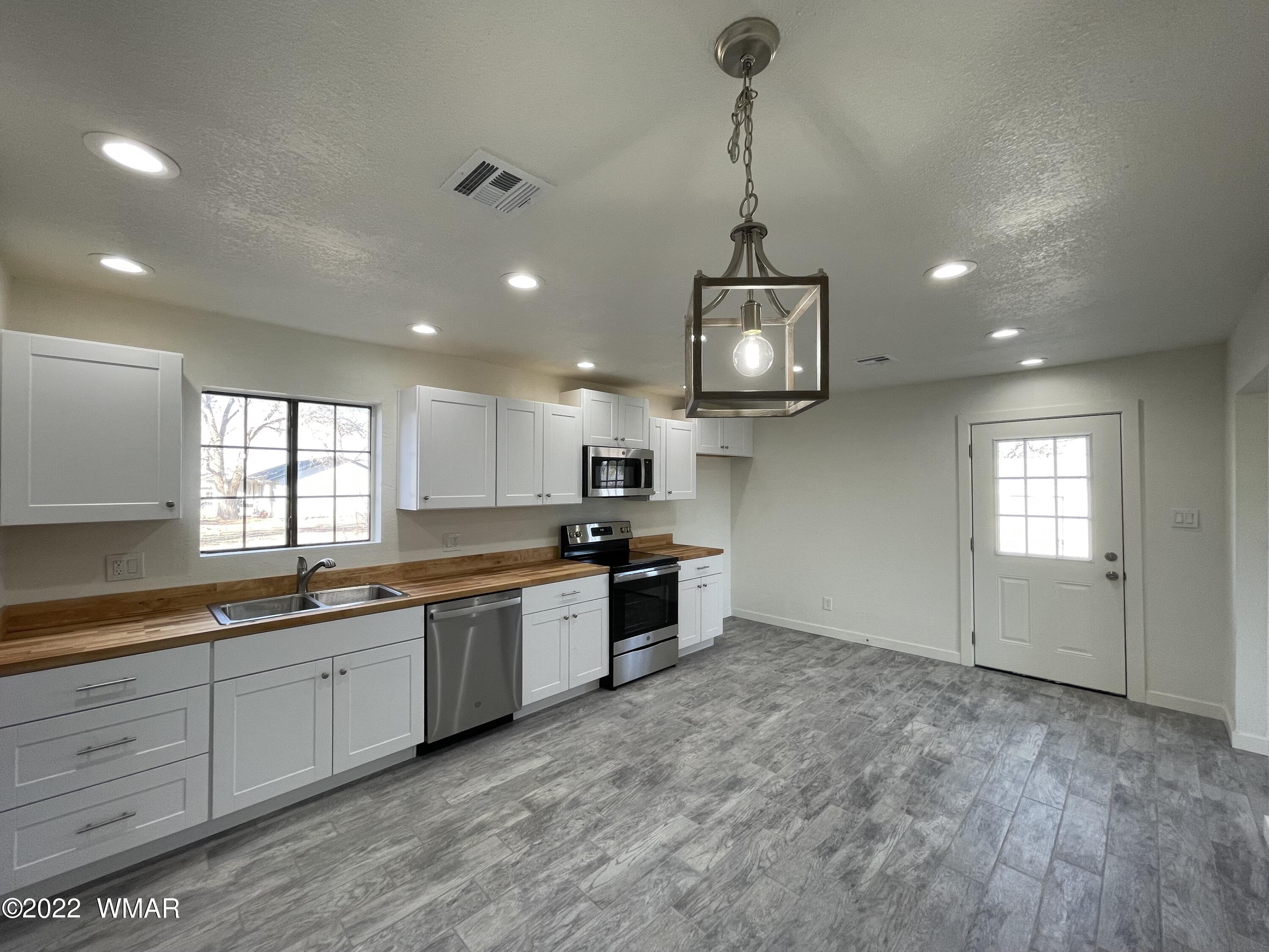 118 East 9th S Street Snowflake, AZ 85937 - Photo 6 of 19 a large kitchen with stainless steel appliances granite countertop a sink and dishwasher a stove top oven with wooden floor