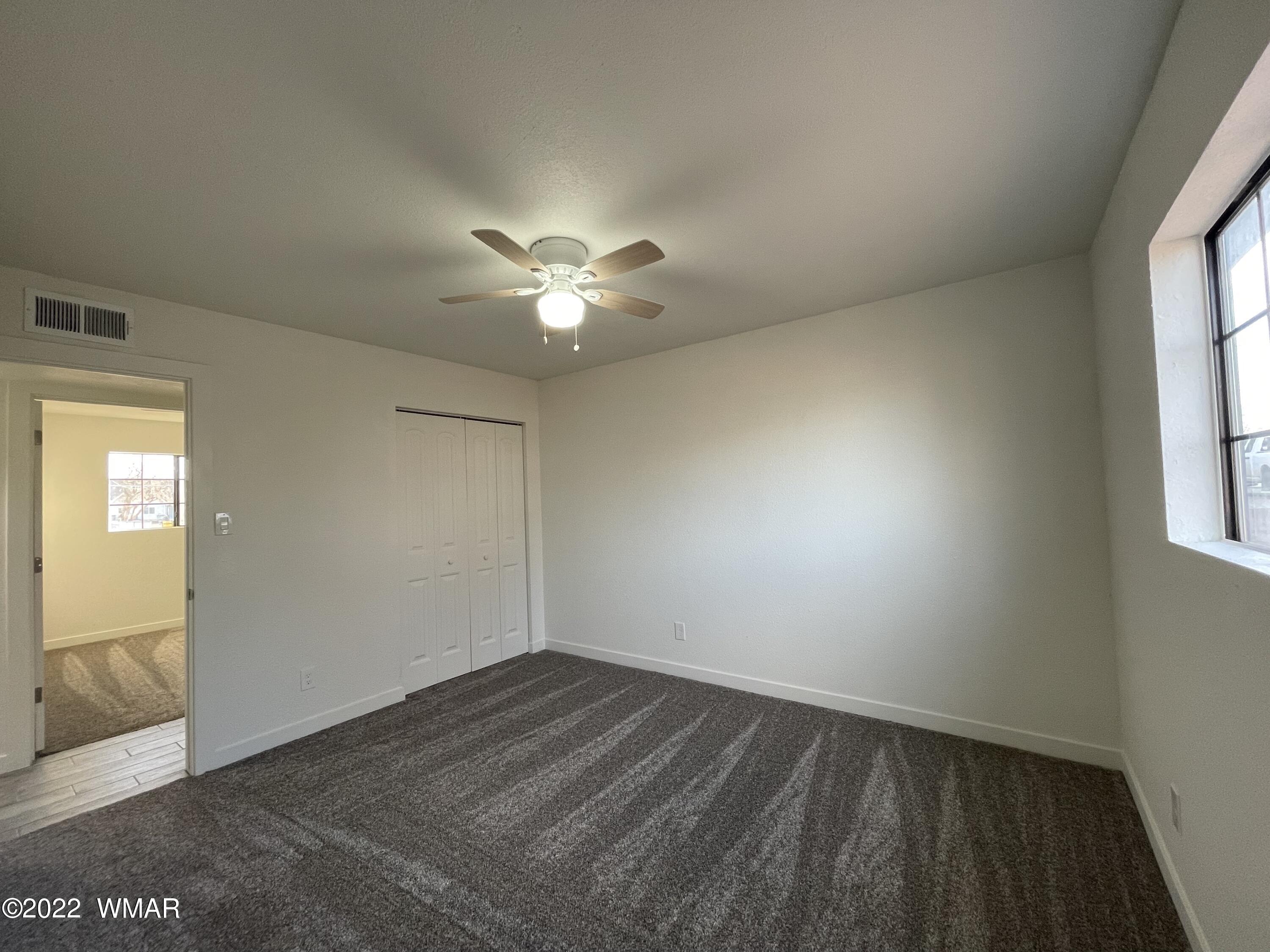 118 East 9th S Street Snowflake, AZ 85937 - Photo 9 of 19 an empty room with a chandelier fan and windows