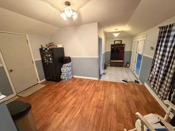 a very nice looking room with wooden floor and washing machine