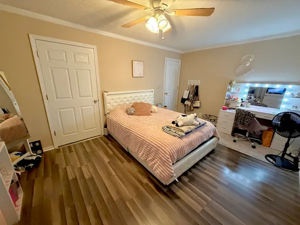 a bedroom with a bed and wooden floor