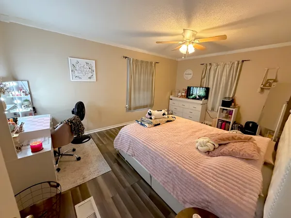 a bedroom with a bed and wooden floor