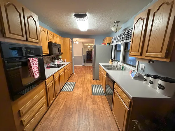 a kitchen with stainless steel appliances granite countertop a refrigerator a stove top oven a sink and dishwasher
