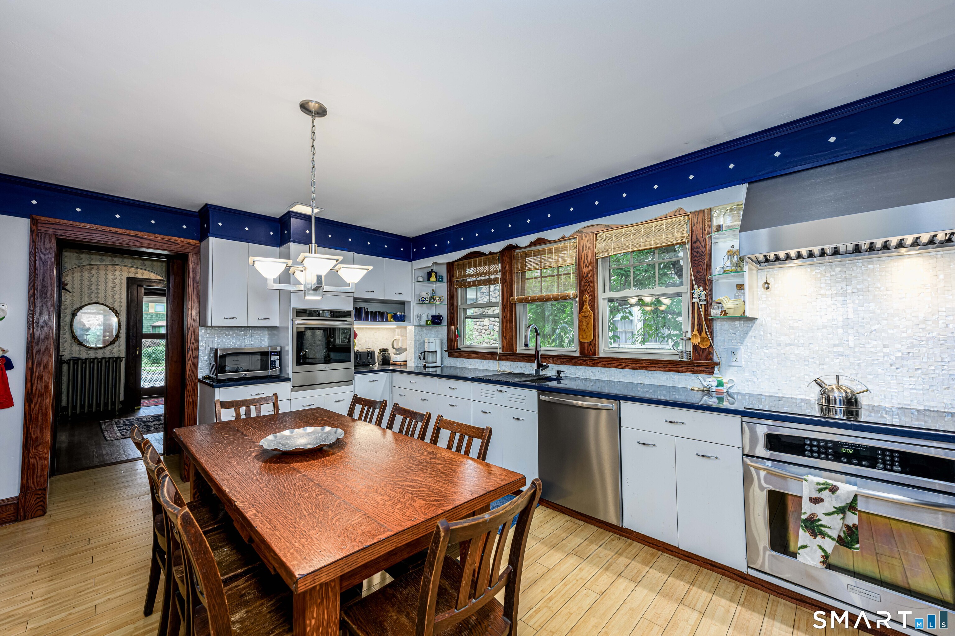 166 Lincoln Street New Britain, CT 06052 - Photo 14 of 40 a kitchen with a stove a sink dishwasher a dining table and chairs with wooden floor